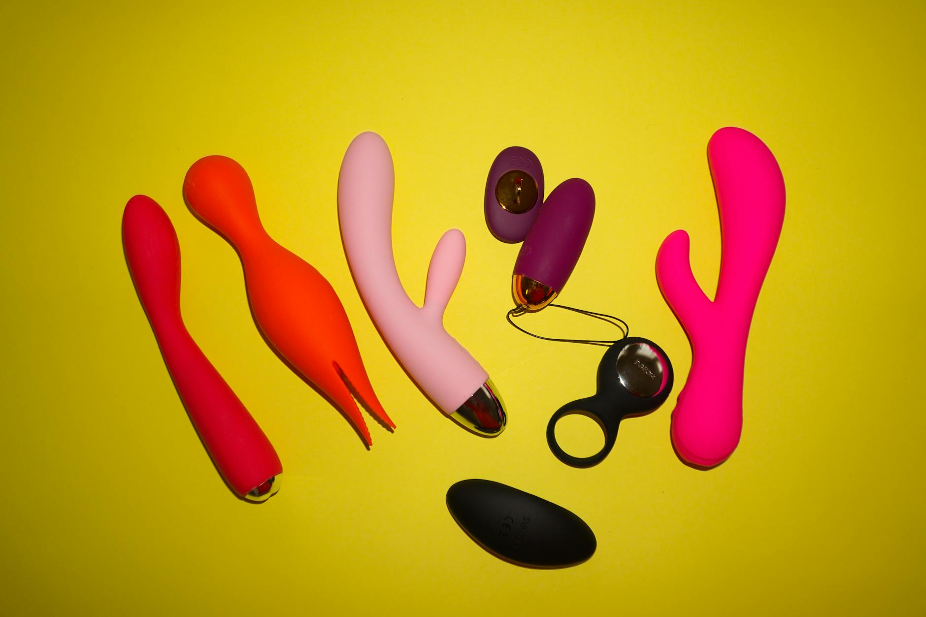 Vibradores coloridos de limão e brinquedos sexuais em fundo amarelo brilhante